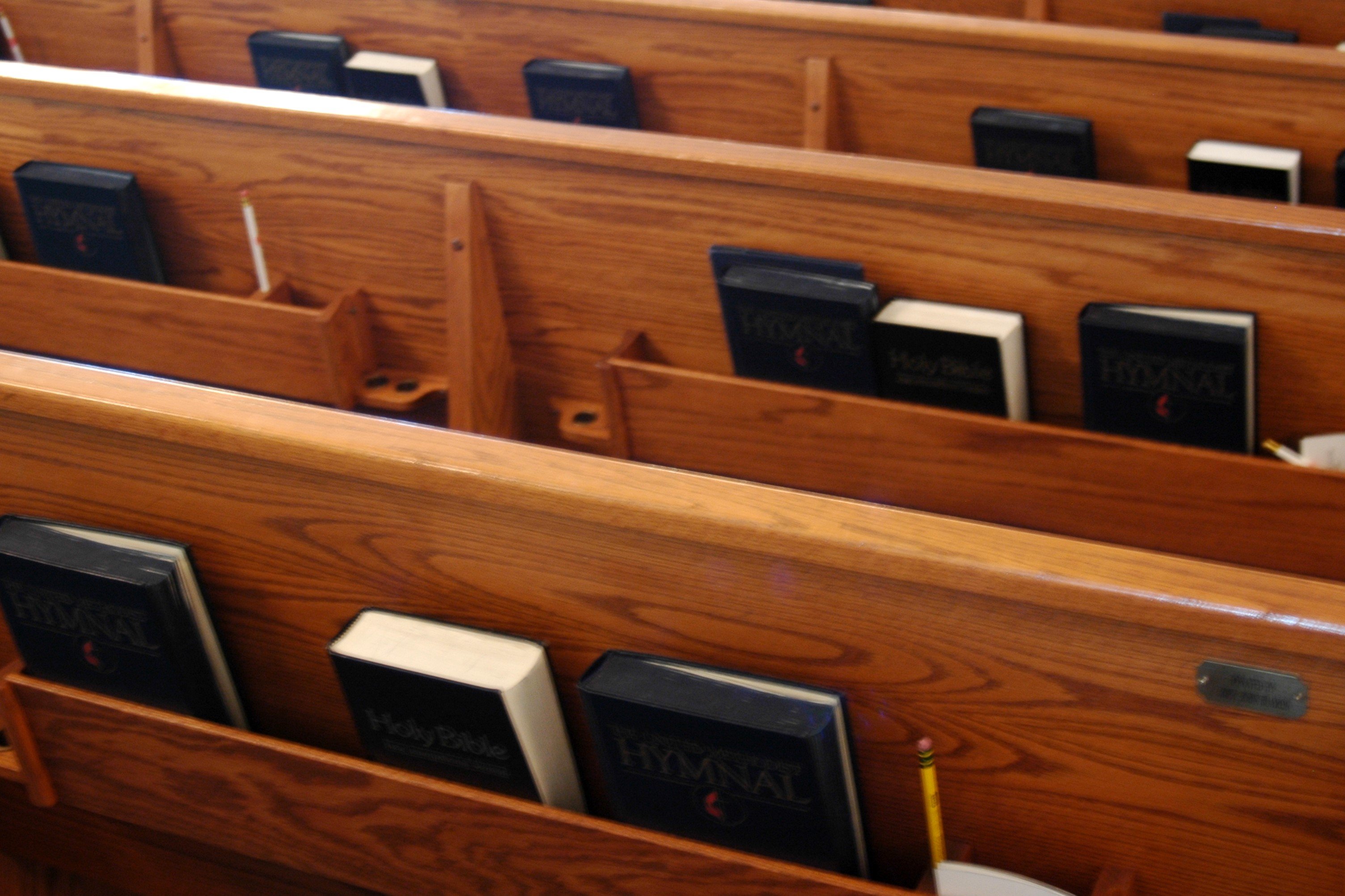 picture of the backs of pews with hymnals in the holder